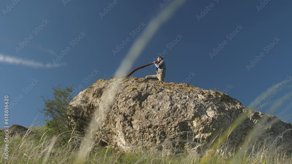 A man plays the Australian Aboriginal musical instrument Didgeridoo on