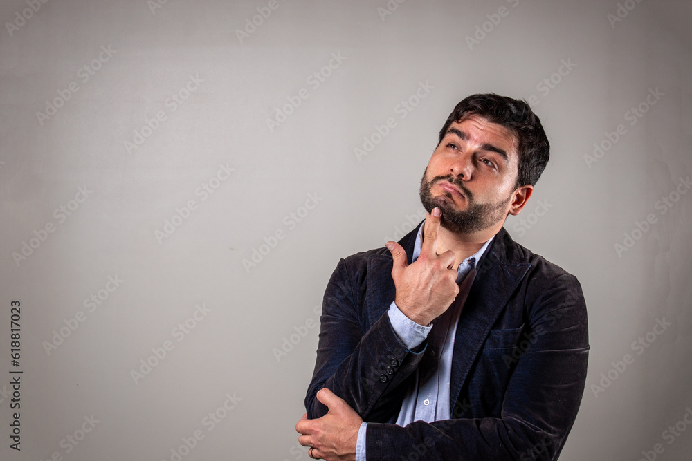 Hombre llevando su mano a la pera en señal de duda y pregunta Hombre llevando su mano a la pera en señal de duda y pregunta