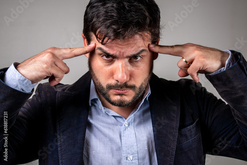 Fototapeta Hombre llevando sus dedos a la sien en señal de pensamiento intenso
