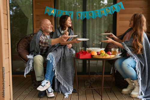 Happy family having birthday party on cottage veranda
