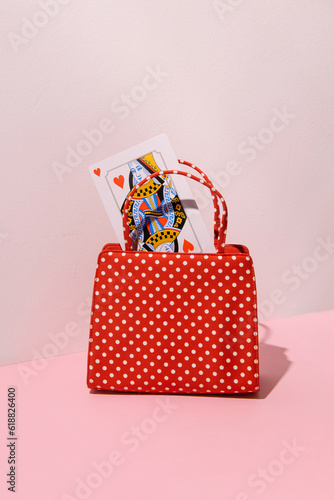 Romantic retro style purse, queen of hearts card in it, creative, aesthetic love game concept. 