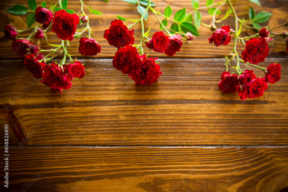 Fototapeta premium bouquet of red small roses, on a wooden background.