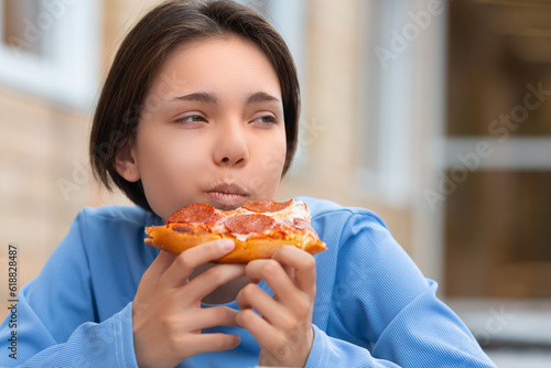 Teenage girl eating pizza.
