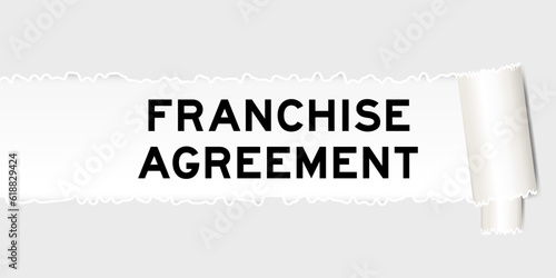 Ripped gray paper background that have word franchise agreement under torn part