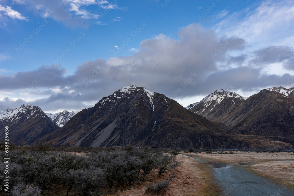 Scenic view along the Mount Cook Road alongside with snow capped Southern Alps basking in the late winter evening light. Best road trip route in New Zealand South Island with majestic Mount Cook. Scenic view along the Mount Cook Road alongside with snow capped Southern Alps basking in the late winter evening light. Best road trip route in New Zealand South Island with majestic Mount Cook.
