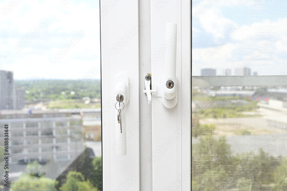 Locks with keys in hand on plastic windows. Protection from falling out of children. Locks with keys in hand on plastic windows. Protection from falling out of children.
