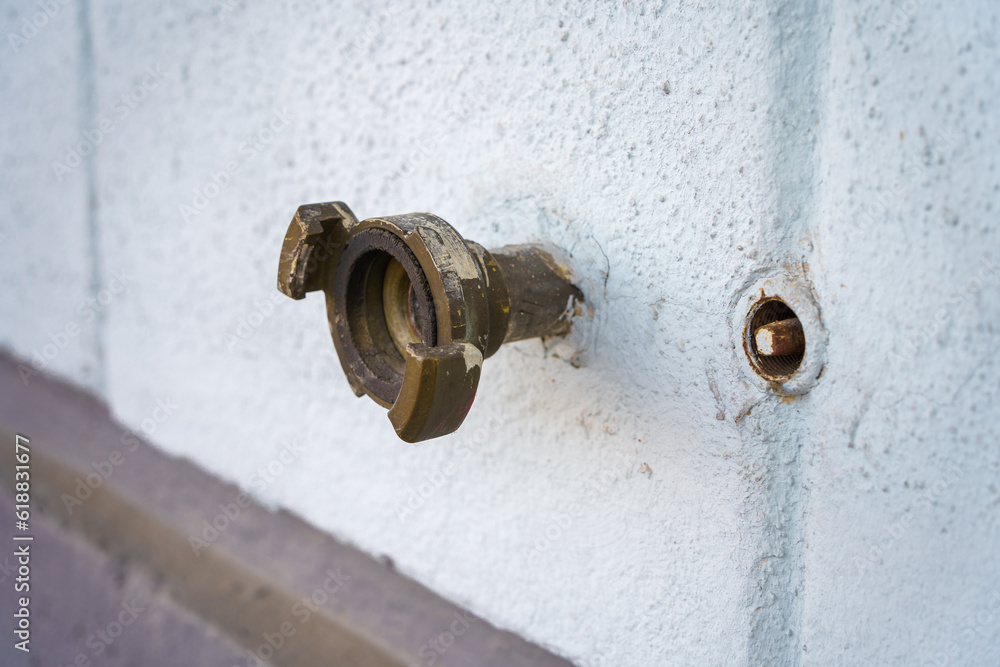 Outdoor water connector on a white concrete wall. Outdoor water connector on a white concrete wall.