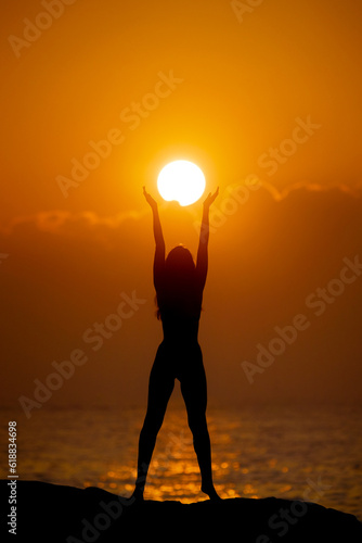 Fotografi Woman Silhouette with Sun Disk in Hands