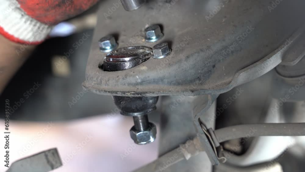 The mechanic is putting the upper control ball joint nut. Repairing the