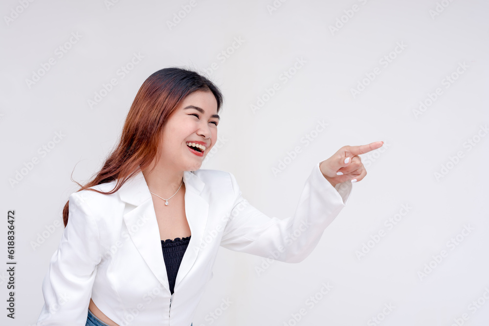 A playful young woman laughingly pointing and facing someone off camera on the right side. Isolated on a white background A playful young woman laughingly pointing and facing someone off camera on the right side. Isolated on a white background
