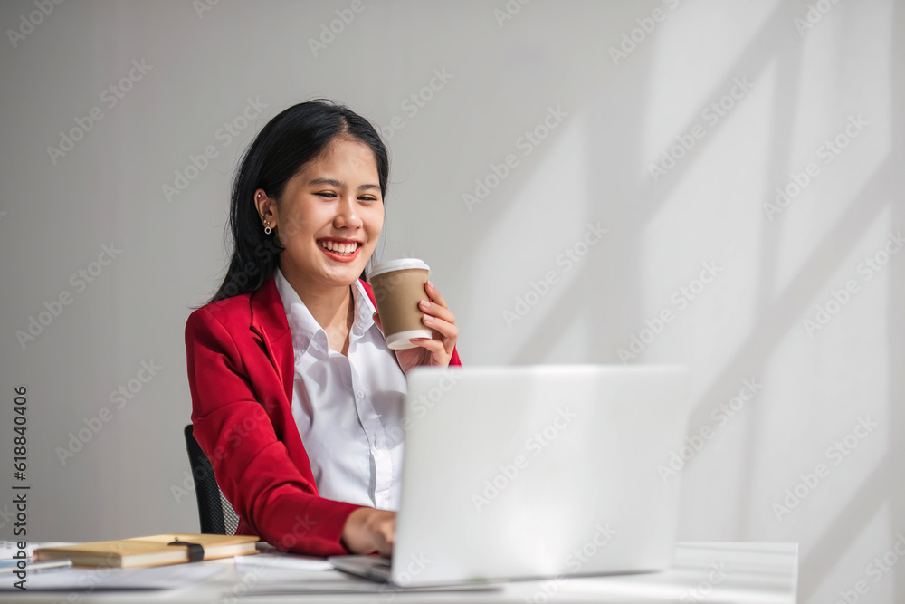 Cheerful business lady working on laptop in office, Asian happy beautiful businesswoman in formal suit work in workplace. Attractive female employee office worker smile. Cheerful business lady working on laptop in office, Asian happy beautiful businesswoman in formal suit work in workplace. Attractive female employee office worker smile.