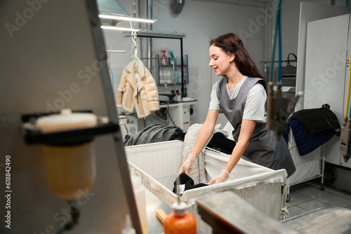 Dry-cleaning operator sorting clothes, checking on presence of stains and tears