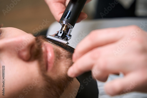 Master barber at work caring for clients beard and mustache