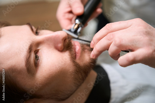 Experienced barber at work caring for clients beard and mustache