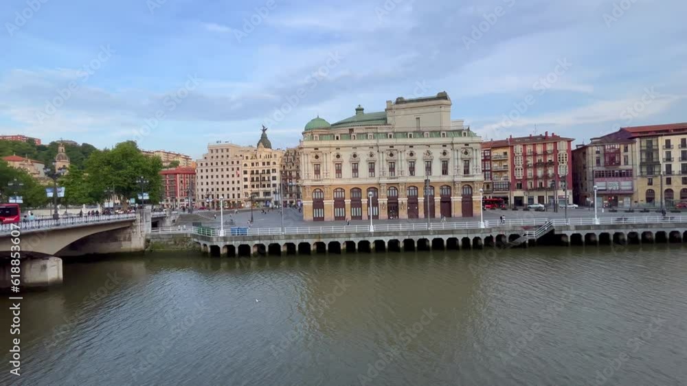 Nervion river and arriaga theater surrounded by buildings from Arenal bridge on sunny day in Bilbao city Nervion river and arriaga theater surrounded by buildings from Arenal bridge on sunny day in Bilbao city