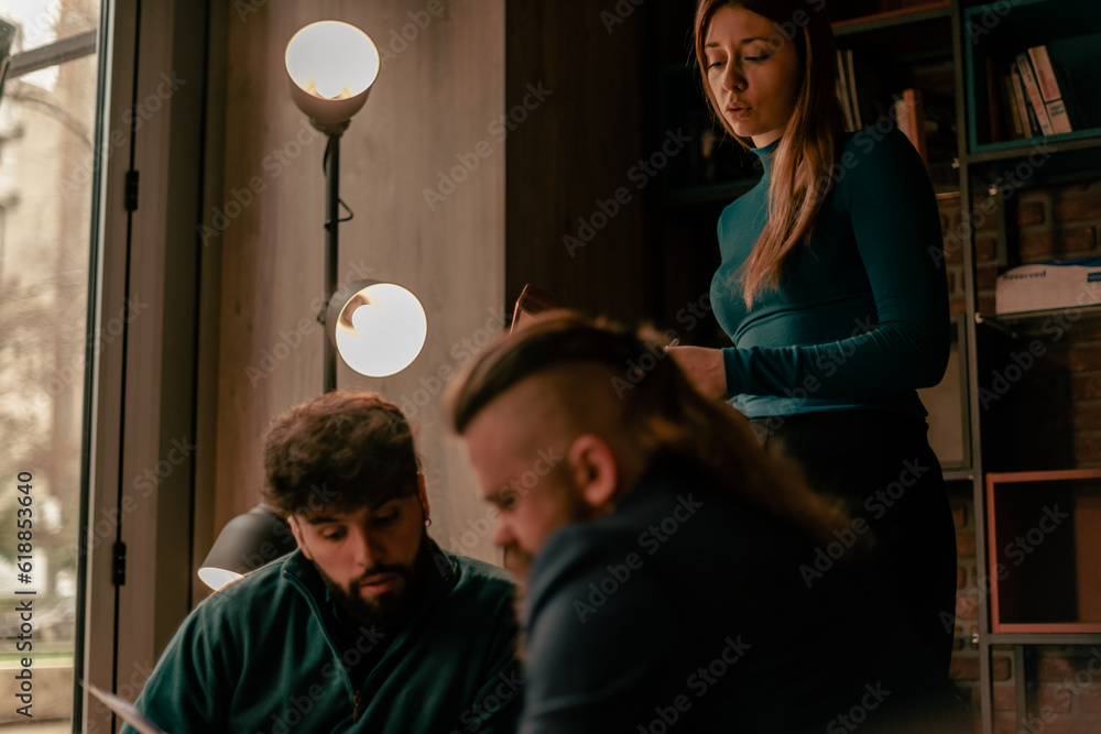 Gorgeous blonde female worker looking at her male colleagues discussing