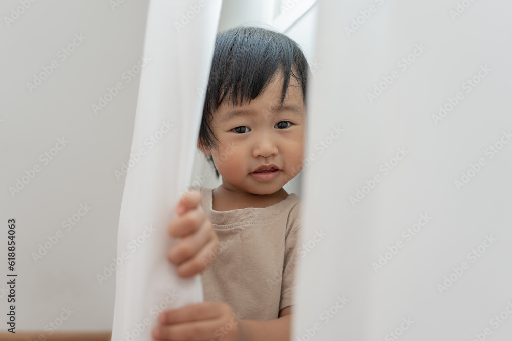 little asian children kid , playing hide and seek standing next a wall house, Adorable child having fun in the home. happy family have fun with kids, activity, learning. little asian children kid , playing hide and seek standing next a wall house, Adorable child having fun in the home. happy family have fun with kids, activity, learning.