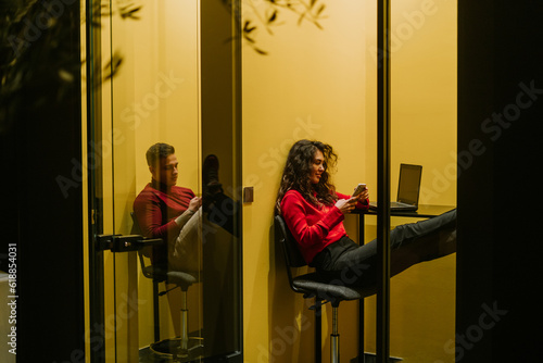 Young business people having phone call in office phone booth photo