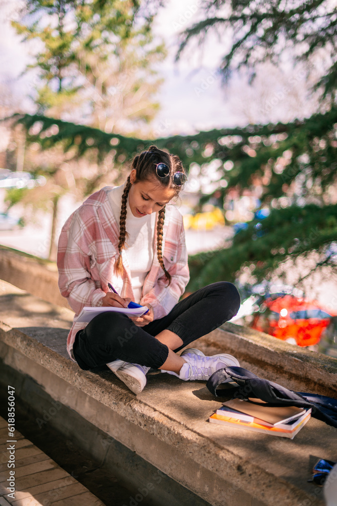 Gorgeous brunette girl using calculator while writing math homework after school