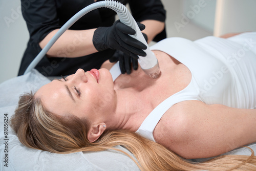 Beautiful woman on the RF lifting procedure in the decollete area