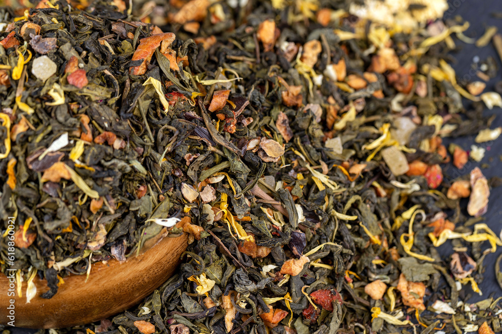 A large amount of dry green tea with pieces of fruit A large amount of dry green tea with pieces of fruit