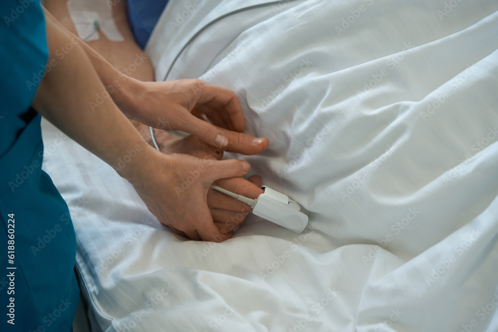 Medic using pulse oximeter with the hospitalized patient in hospital Medic using pulse oximeter with the hospitalized patient in hospital