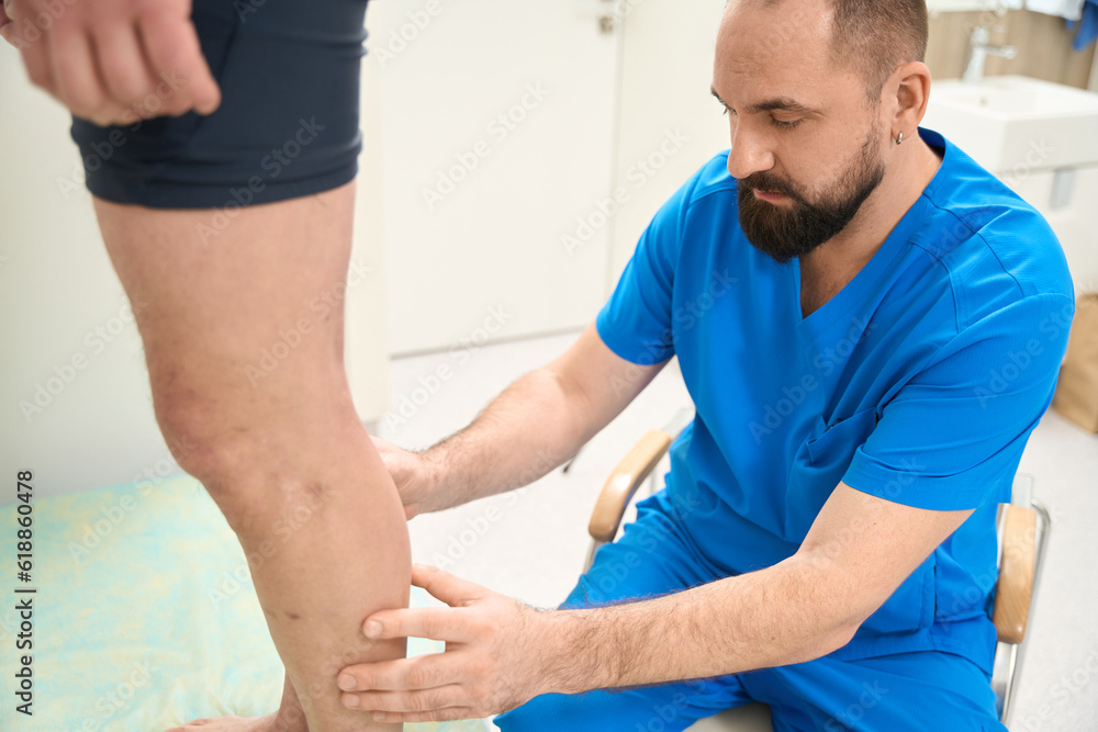 Obraz premium Physician looking patient legs in the clinic