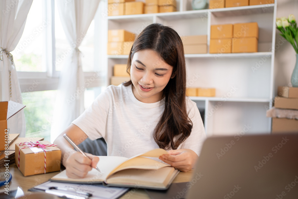 Woman Writing Customer Details for Shipping in Home Office, Packing Box and Writing Customer Information for Efficient Shipping, E-Commerce and Online Selling Concept. Woman Writing Customer Details for Shipping in Home Office, Packing Box and Writing Customer Information for Efficient Shipping, E-Commerce and Online Selling Concept.