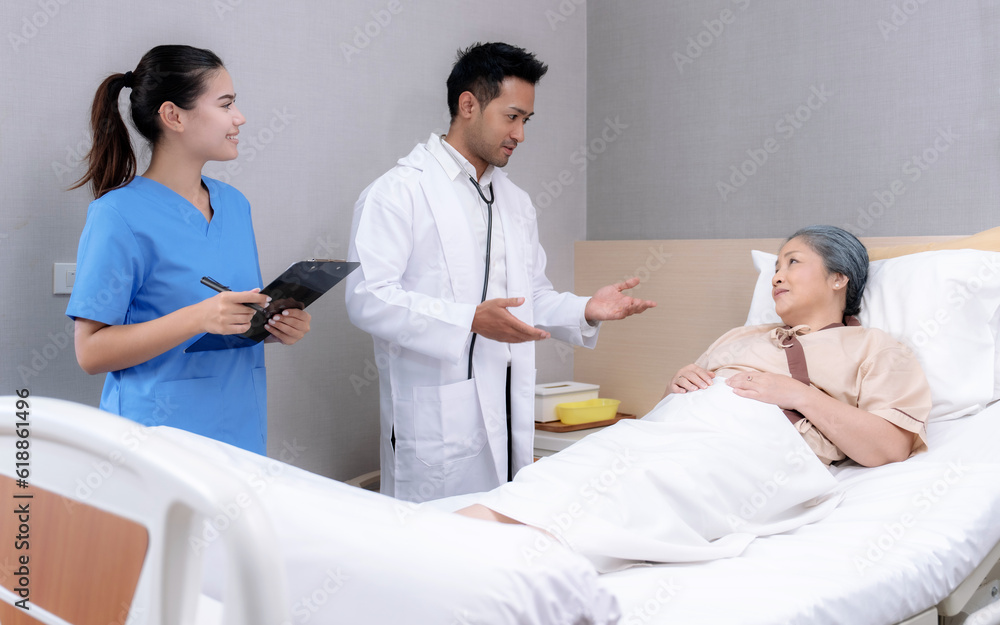 Obraz premium Elderly Asian woman is being treated at a hospital under close supervision of doctors and nurses.