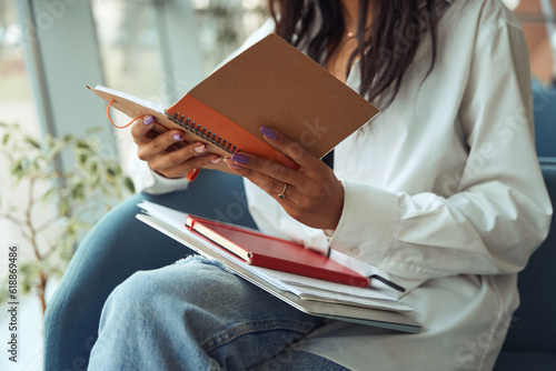 Hands of female holding copy book indoors