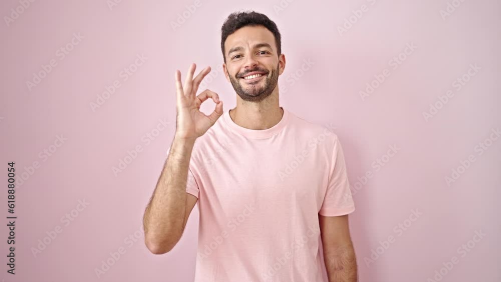 Young hispanic man doctor doing ok gesture over isolated pink background Young hispanic man doctor doing ok gesture over isolated pink background
