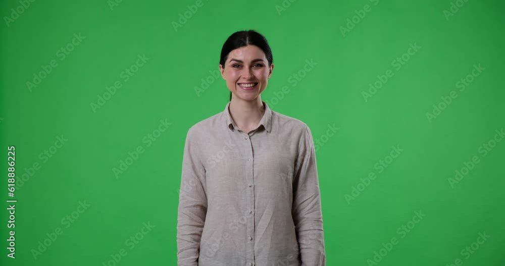 Cheerful Caucasian woman with a ponytail stands on a green screen background and nods head while saying yes with a smile on face. She is wearing casual clothing and appears confident and positive. Cheerful Caucasian woman with a ponytail stands on a green screen background and nods head while saying yes with a smile on face. She is wearing casual clothing and appears confident and positive.