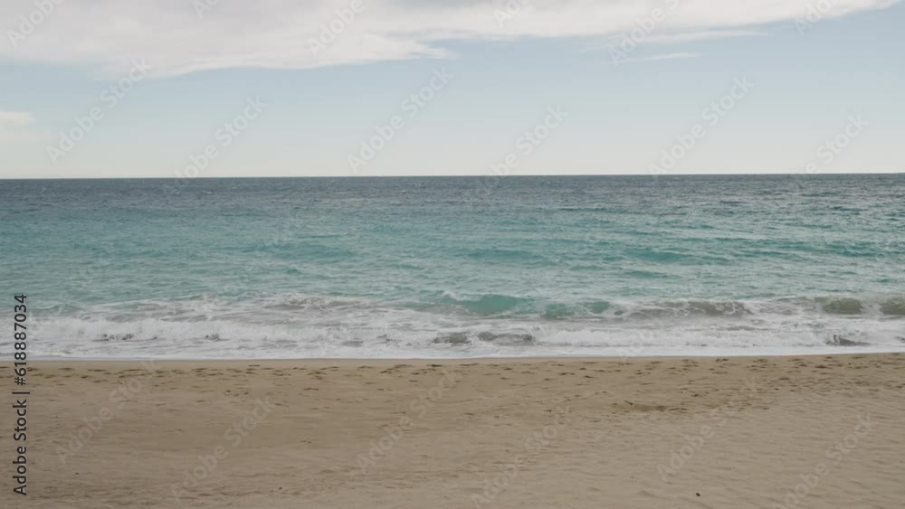 Slow motion clear blue waves with strong wind on a sandy empty beach in Cannes in spring Slow motion clear blue waves with strong wind on a sandy empty beach in Cannes in spring