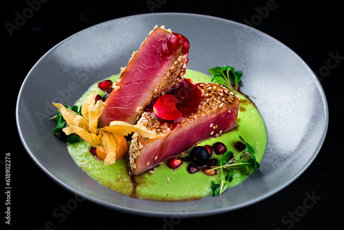Seared tuna with sesame, physalis, cranberry, pomegranate, sauce and microgreens.