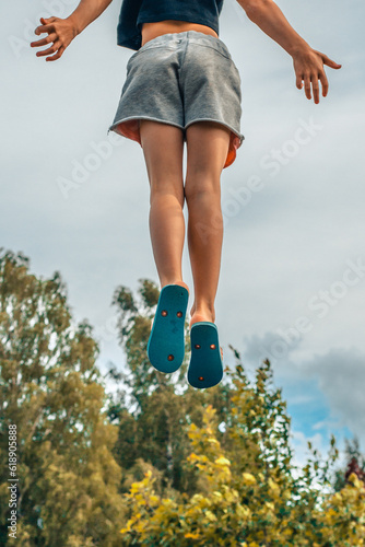 A child jumps on a trampoline. The girl jumped in the air. A child with positive emotions jumps. Jumping on a trampoline can be a wonderful and enjoyable activity for children, promoting physical