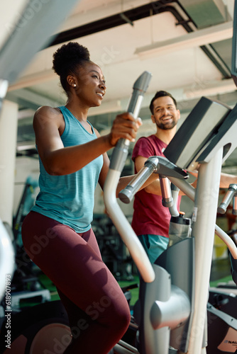 Cuadro en lienzo Black female athlete working out on cross trainer in health club.