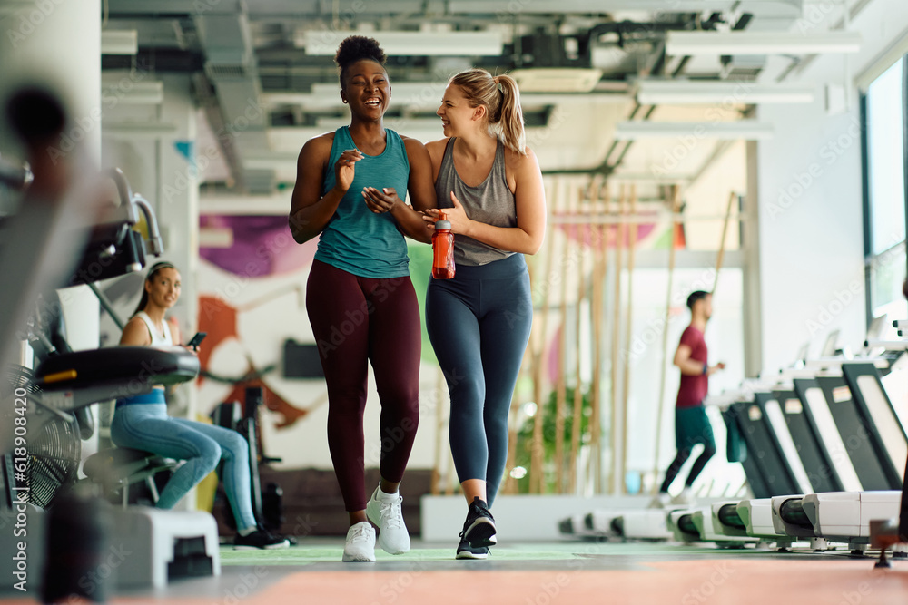 Cheerful athletic women having fun during sports training in gym.