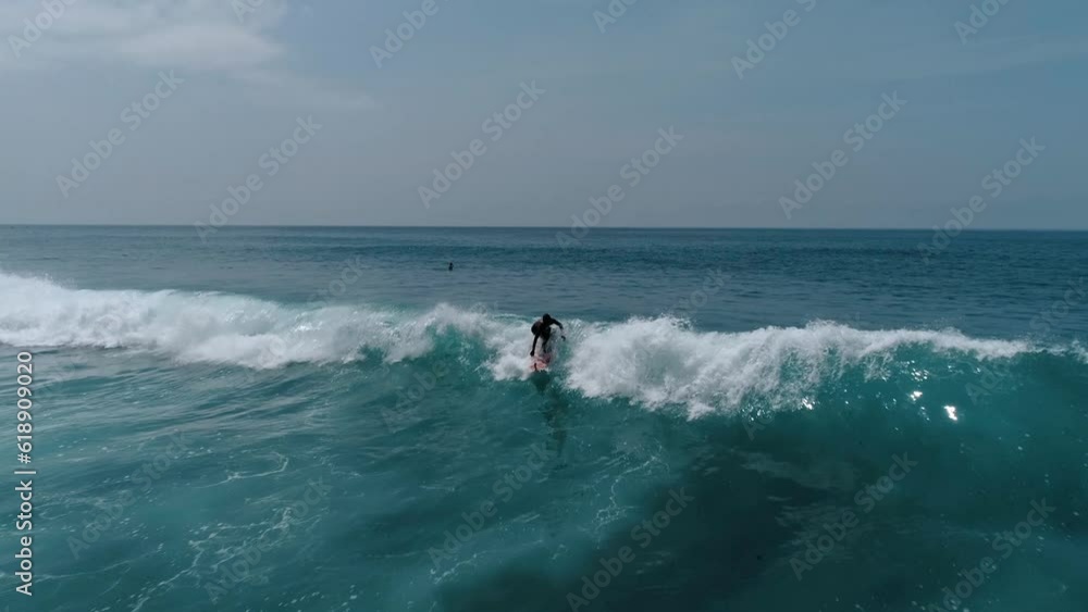 Aerial Panning Shot Of Men Surfing On Waves In Sea Against Cloudy Sky During Sunny Day Aerial Panning Shot Of Men Surfing On Waves In Sea Against Cloudy Sky During Sunny Day