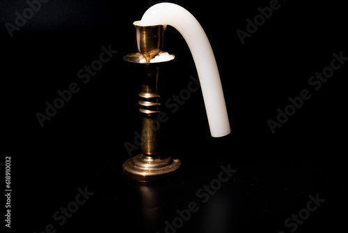 a bent candle that stood in the sun. cutting in a candlestick on a black background.