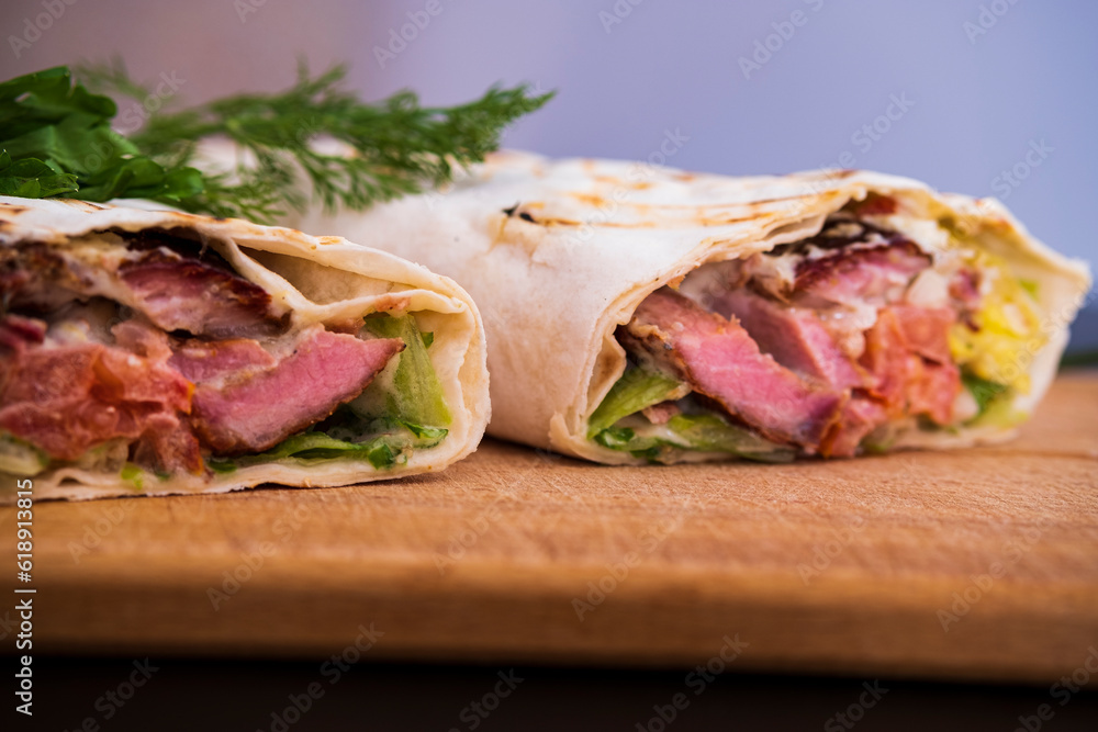 Delicious kebab with meat, lettuce, tomato, onion and sauce with french fries. Delicious kebab with meat, lettuce, tomato, onion and sauce with french fries.