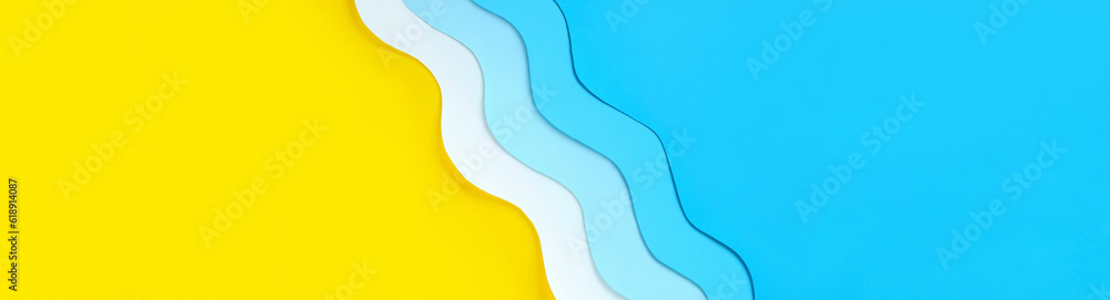 Seashore diagonal long banner with copy space. Summer holidays background with yellow beach sand and paper cut out blue waves. Relaxation on vacations. The ocean coast layout.