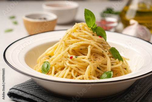 Spaghetti aglio e olio. Traditional Italian pasta with garlic, olive oil and chili peppers in plate on concrete background.