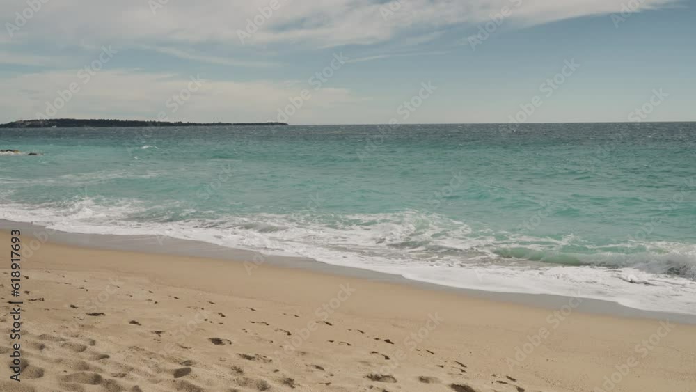 Slow motion clear blue waves with strong wind on a sandy empty beach in Cannes in spring Slow motion clear blue waves with strong wind on a sandy empty beach in Cannes in spring