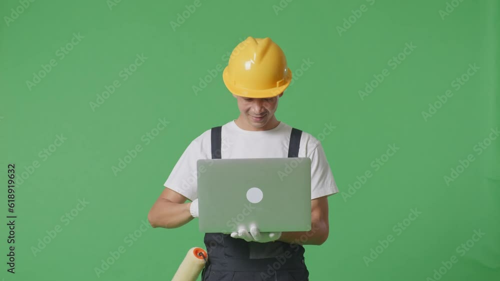 Asian Man Painter Wearing Safety Helmet Using A Laptop And Smiling While Standing In The Green Screen Background Studio
Asian Man Painter Wearing Safety Helmet Using A Laptop And Smiling While Standing In The Green Screen Background Studio