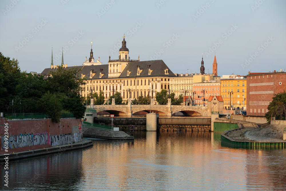 Obraz premium Wroclaw, Poland - June 02, 2023: Cityscape on city buildings across the river and bridge in Wroclaw, Poland