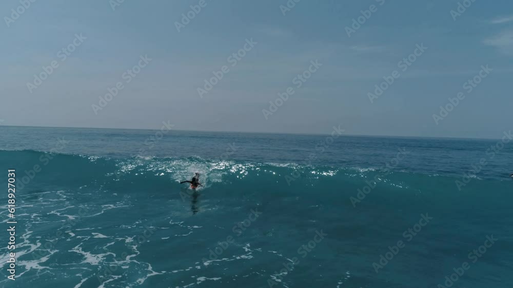 Aerial Panning Shot Of Men Surfing On Waves In Sea Against Cloudy Sky During Sunny Day Aerial Panning Shot Of Men Surfing On Waves In Sea Against Cloudy Sky During Sunny Day