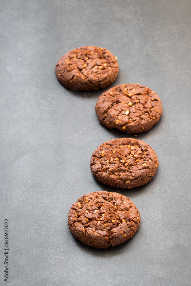 Vegan Cocoa oatmeal cookies with crushed peanuts. Dark gray background Vegan Cocoa oatmeal cookies with crushed peanuts. Dark gray background