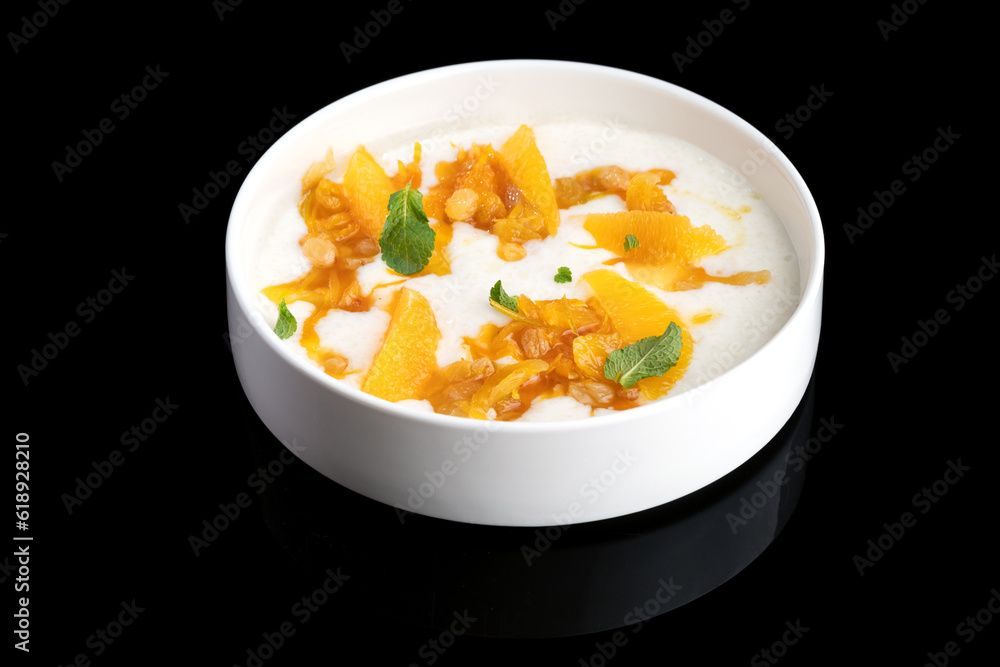 Sweet homemade peach yogurt with pieces in a white plate Sweet homemade peach yogurt with pieces in a white plate
