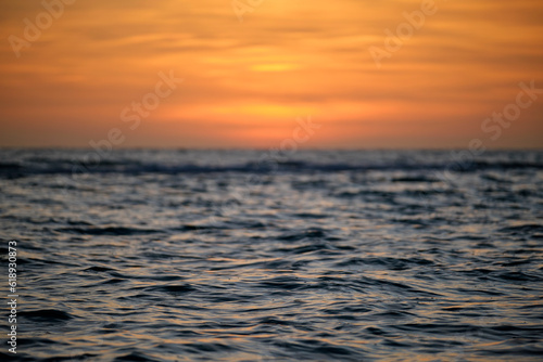 Dramatic red ocean waves at sunset with soft evening sea dark water