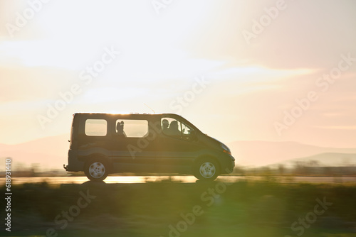 Foto Passenger van driving fast on intercity road at sunset